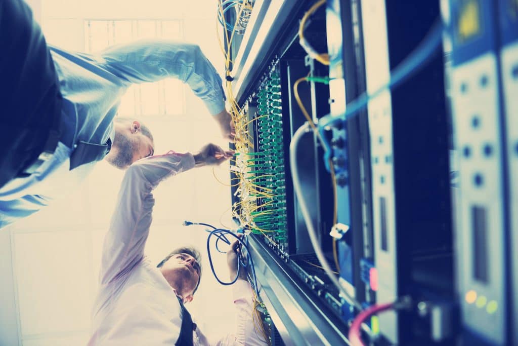 a man standing in front of a server in a server room.