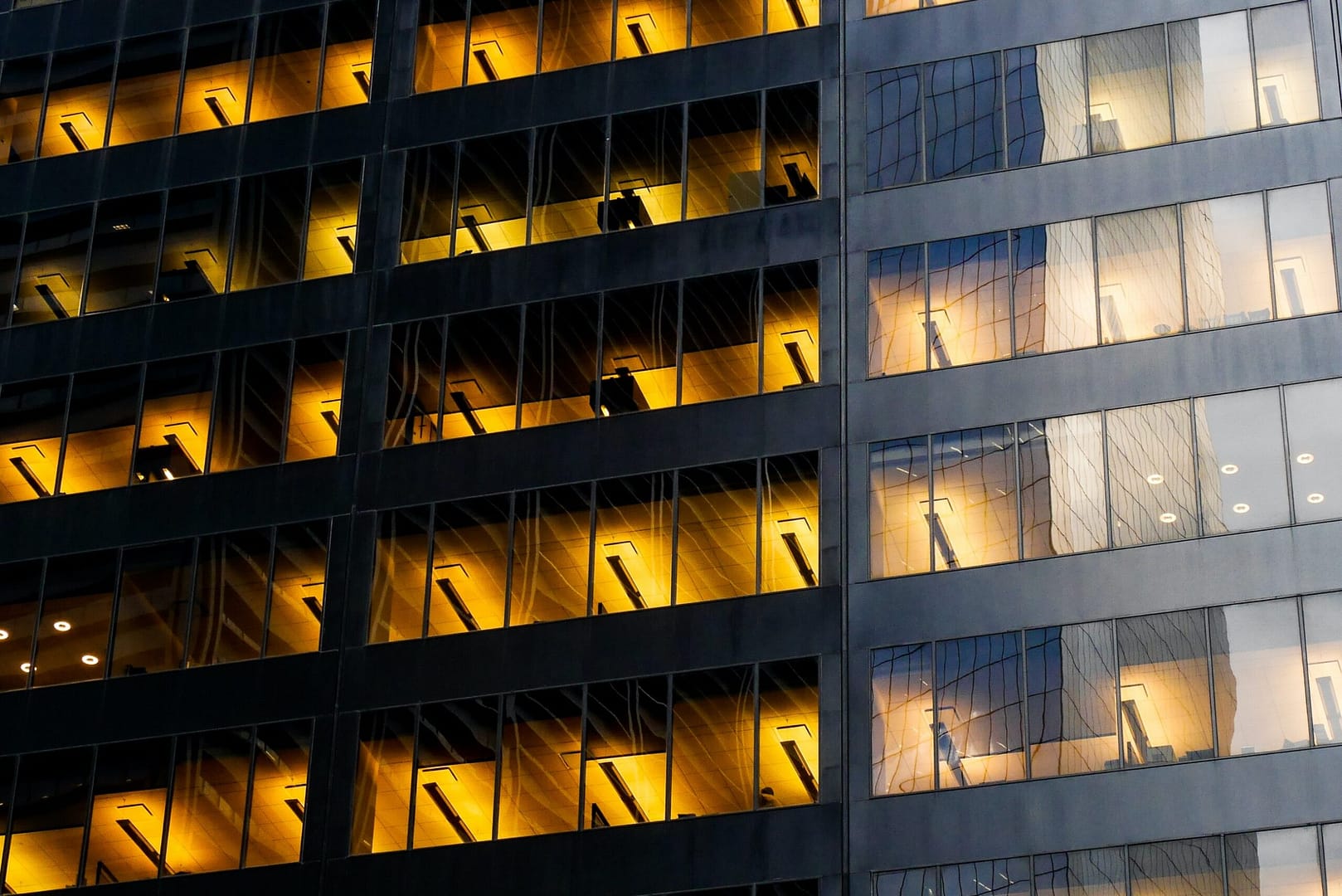 Office building at night with the lights still turned on, wasting energy. BRIGHTER, the AI-driven software that optimizes HVAC for commercial buildings is the best solution to prevent energy waste