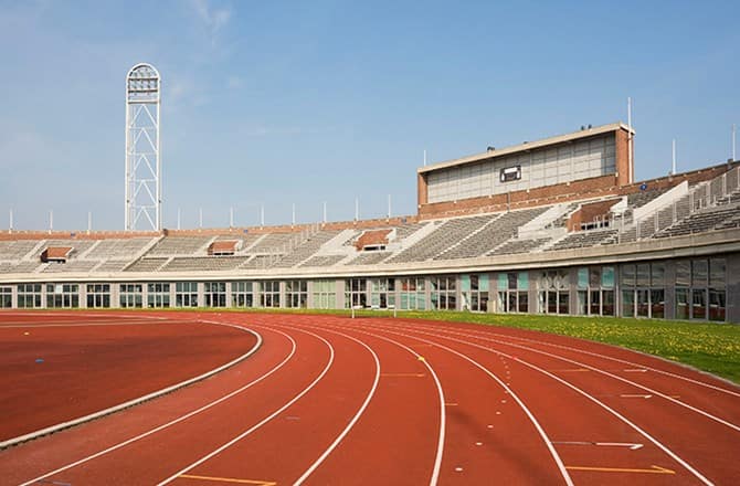 an empty stadium with a red track running through it.